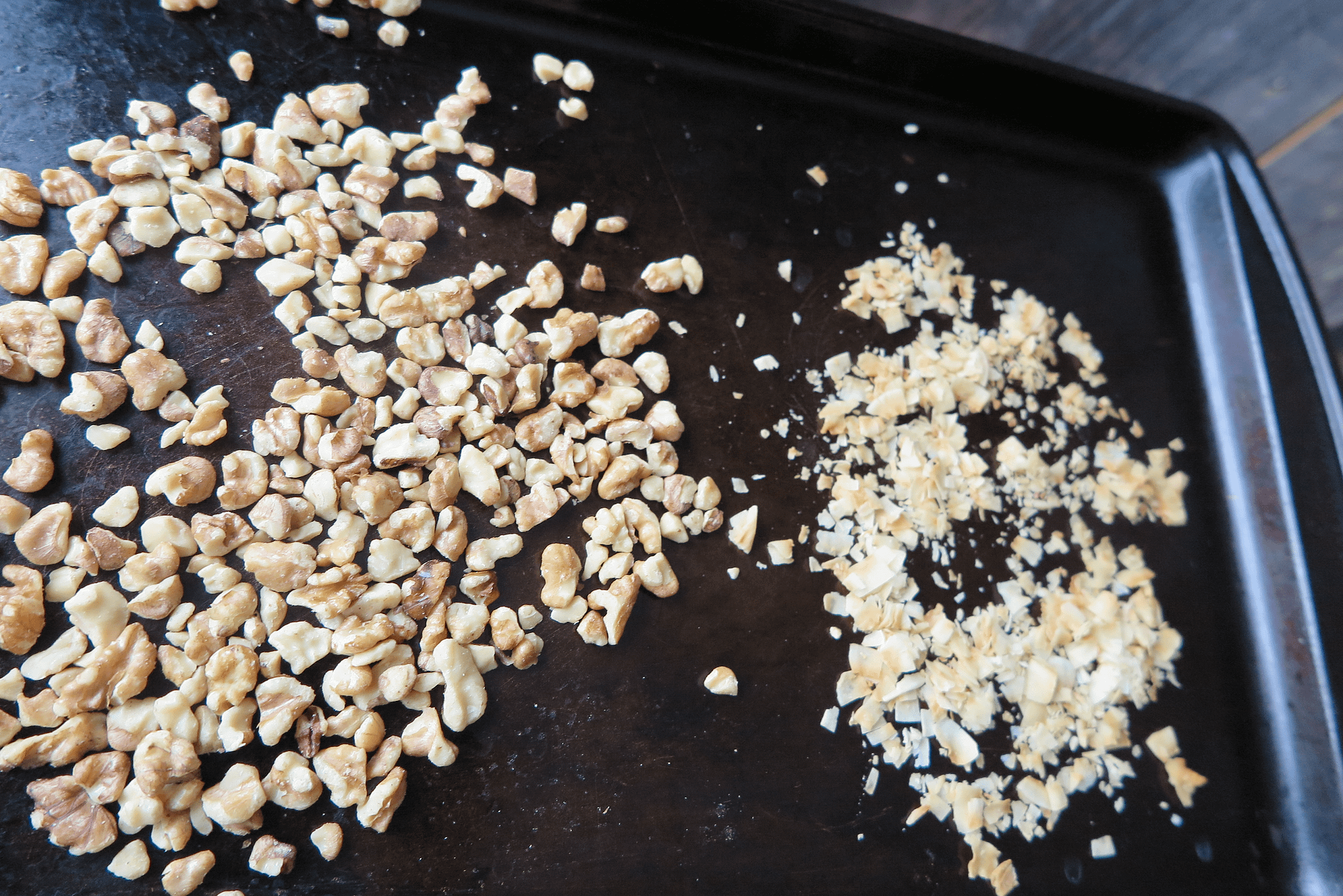 A griddle with chopped nuts and flaked coconut scattered over top