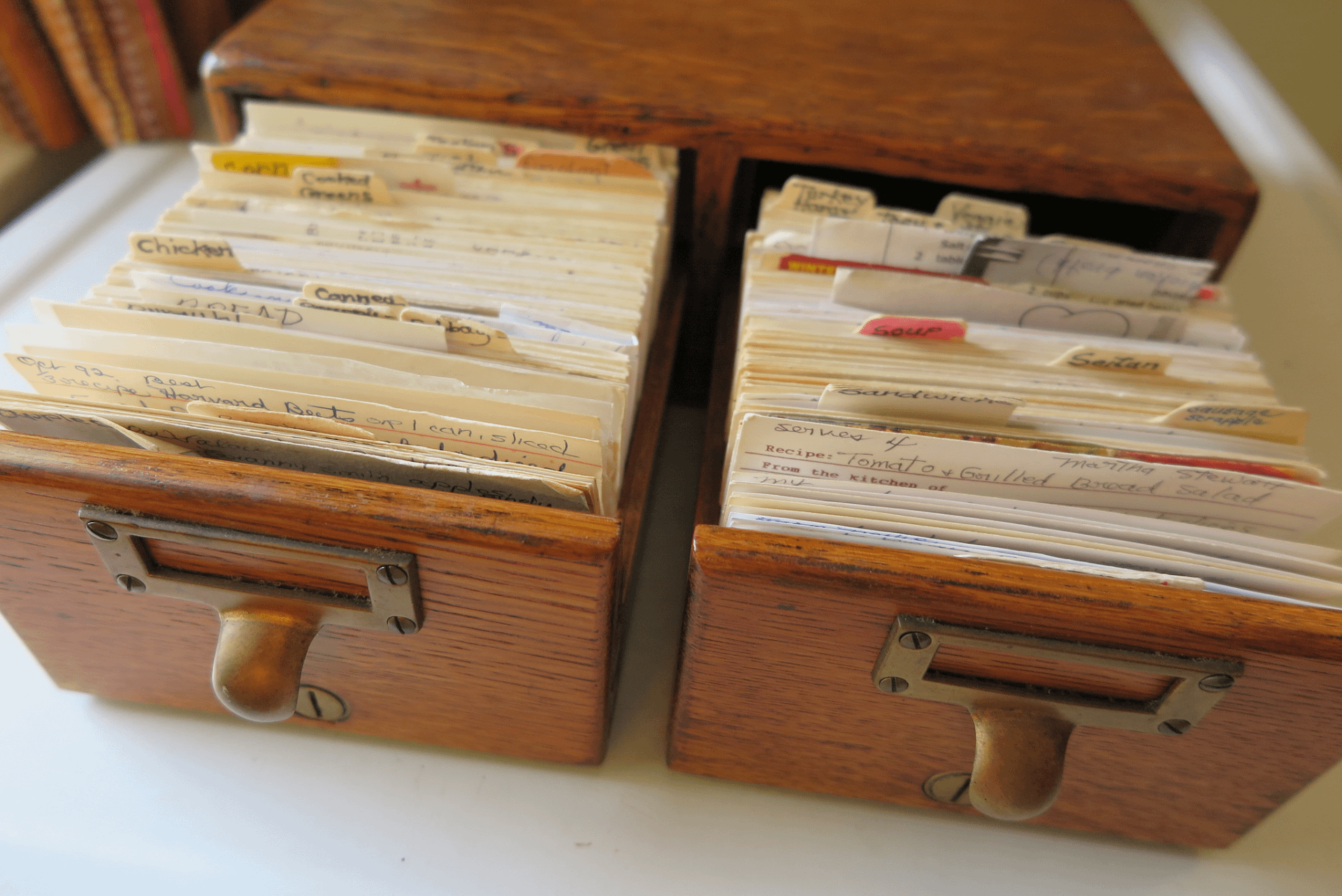 A library file card style recipe box with tow drawers, both opened to show the many recipe cards inside