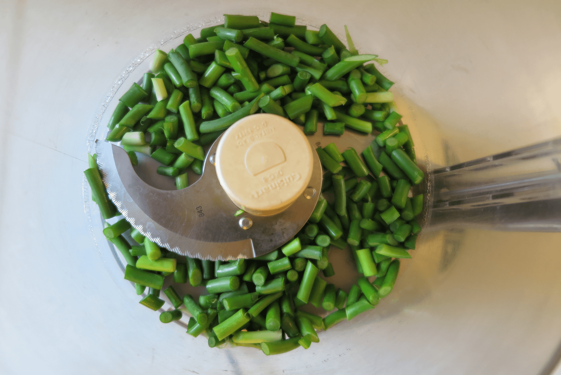 Chopped garlic scapes in a food processor